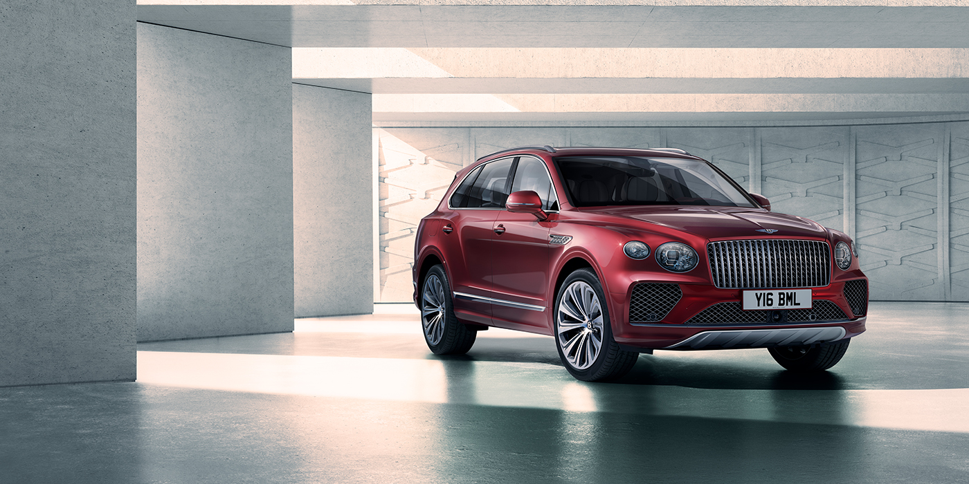 Bentley Jeddah Bentley Bentayga Atelier Edition SUV in Rubino Red paint front three quarter against textured concrete wall